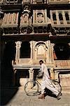 Homme marchant avec vélo à l'extérieur de Jaisalmer, Rajasthan, Inde