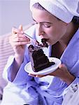 Woman in Bathrobe, Eating Slice Of Chocolate Cake