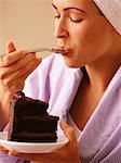 Woman in Bathrobe, Eating Slice Of Chocolate Cake