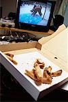 Pizza-Schachtel auf Tisch mit Blick auf Fernseher