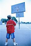 Back View of Boy Playing Basketball on Outdoor Court