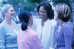 Four Women Standing Outdoors Laughing