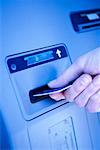 Close-Up of Hand Inserting Card In Bank Machine