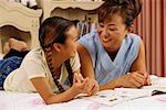 Mother and Daughter Lying on Bed Talking