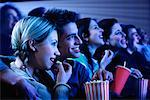 Jeune Couple regarder film dans le théâtre, le sourire