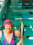 Ältere Frau mit Ladder im Pool
