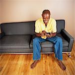 Man Sitting on Sofa Using Electronic Organizer