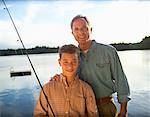 Back View of Father and Son on Dirt Road with Fishing Gear - Stock