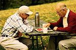 Two Mature Men Playing Checkers Outdoors