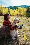 Woman and Dog Sitting in Field