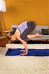 Frau praktizieren Yoga in ihrem Wohnzimmer