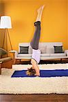 Femme à pratiquer le Yoga dans son salon