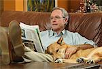Homme assis sur un canapé avec chien