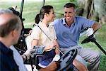 Golfers in Golf Carts Comparing Scores