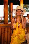 Woman Using Cell Phone at Tropical Bar