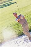 Man Golfing out of Sand Trap