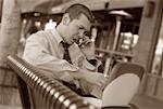 Businessman with Cell Phone and Laptop Outdoors