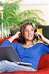 Girl Using Laptop Computer and Phone