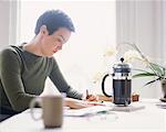 Woman Writing at Kitchen Table