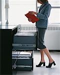 Businesswoman Looking In Filing Cabinet