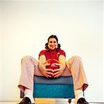 Woman Sitting in Chair Holding Bowling Ball