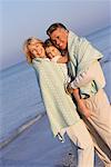 Grands-parents avec petite fille sur la plage