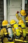 Pompiers sur le point d'entrer dans la maison en feu