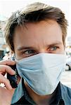 Man Wearing Face Mask, Using Cell Phone Outdoors