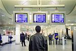 Back of Man Looking at Arrival And Departure Monitors