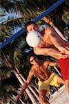 Two Men Playing Volleyball on Tropical Beach