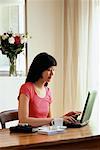 Woman Holding Credit Card and Using Laptop Computer