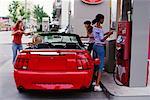 Teenage Girls Putting Gas in Car