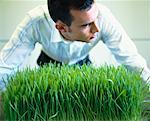 Businessman Leaning over Grass