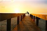 Woman Stretching on Beach Boardwalk