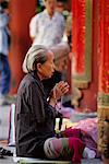 Femme de prière dans le Temple de Kowloon, Hong Kong