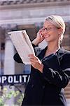 Businesswoman with Cell Phone and Newspaper