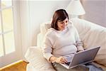 Frau auf Sofa mit Laptop