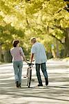 Couple Walking down Country Road With Bicycle