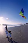 Mother and Daughter Flying Kite on Beach