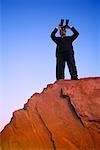 Businessman on Cliff with Binoculars