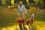 Homme avec chien poussant brouette