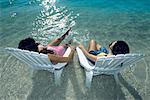 Virgin Islands, women sunbathing with their feet in the water