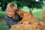 Junge mit gelber Labrador Welpe