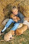 Boy with Yellow Labrador Retriever Puppies