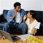 Couple Sitting on Sofa Discussing Their Personal Finances