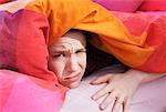 Woman Hiding Under Covers in Bed