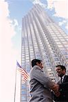 Hommes d'affaires secouant les mains extérieur Office Tower