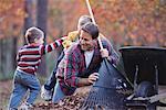Father and Sons Raking Leaves