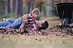 Father and Son Lying on Raked Leaves