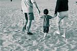 Parents avec fils de marche sur la plage